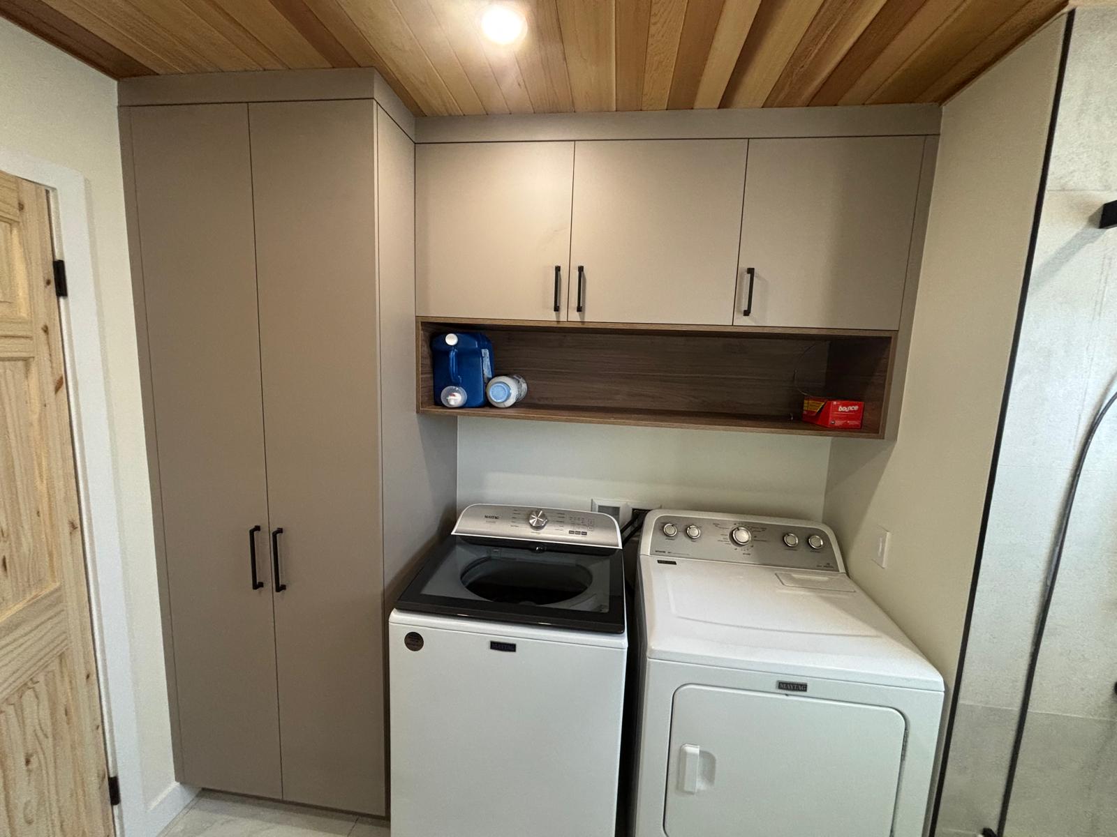 Buanderie sur mesure avec armoires greige, colonne de rangement pleine hauteur et tablette en bois